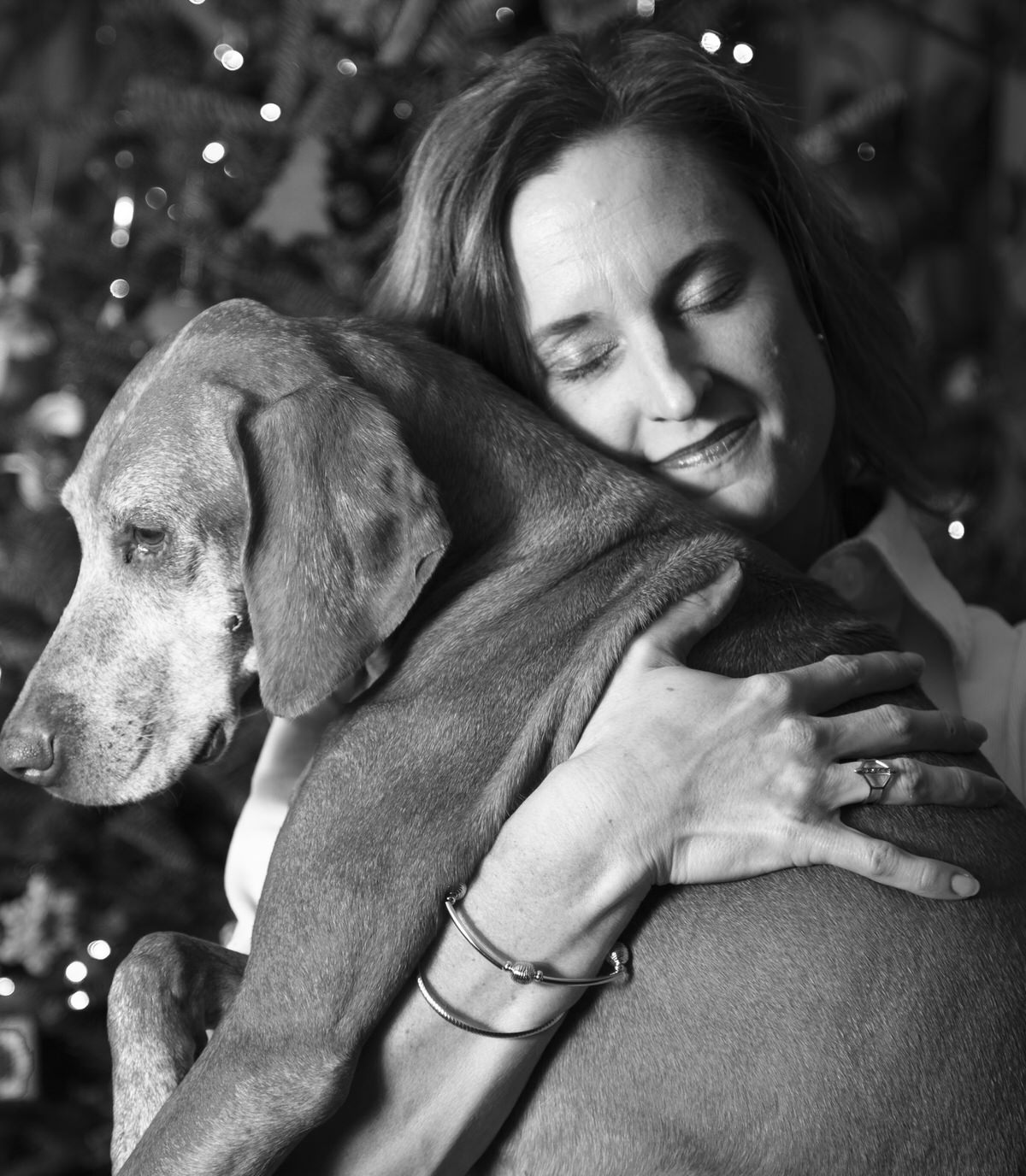 Woman hugs her dog for family portraits