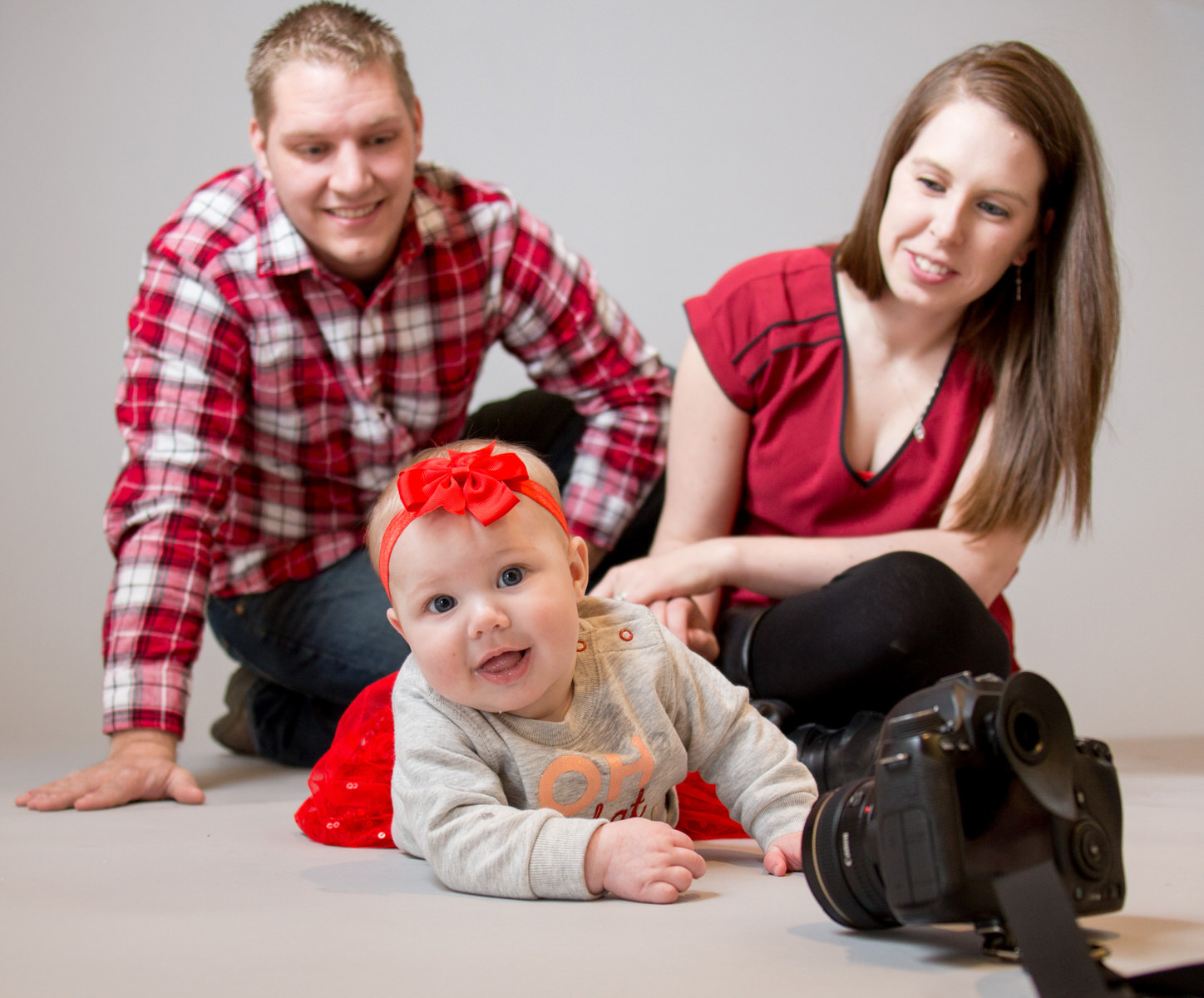 Baby crawls on tummy to reach for camera during family portraits in Erie, PA