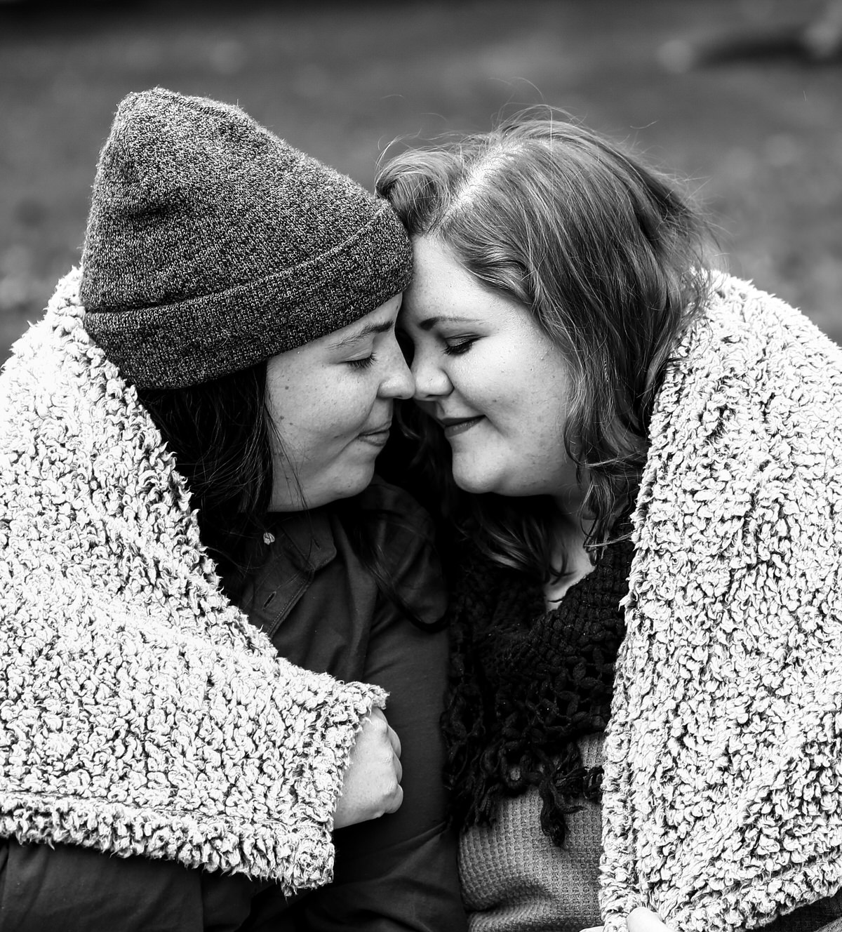 Couple snuggles under a blanket for portraits in Erie PA