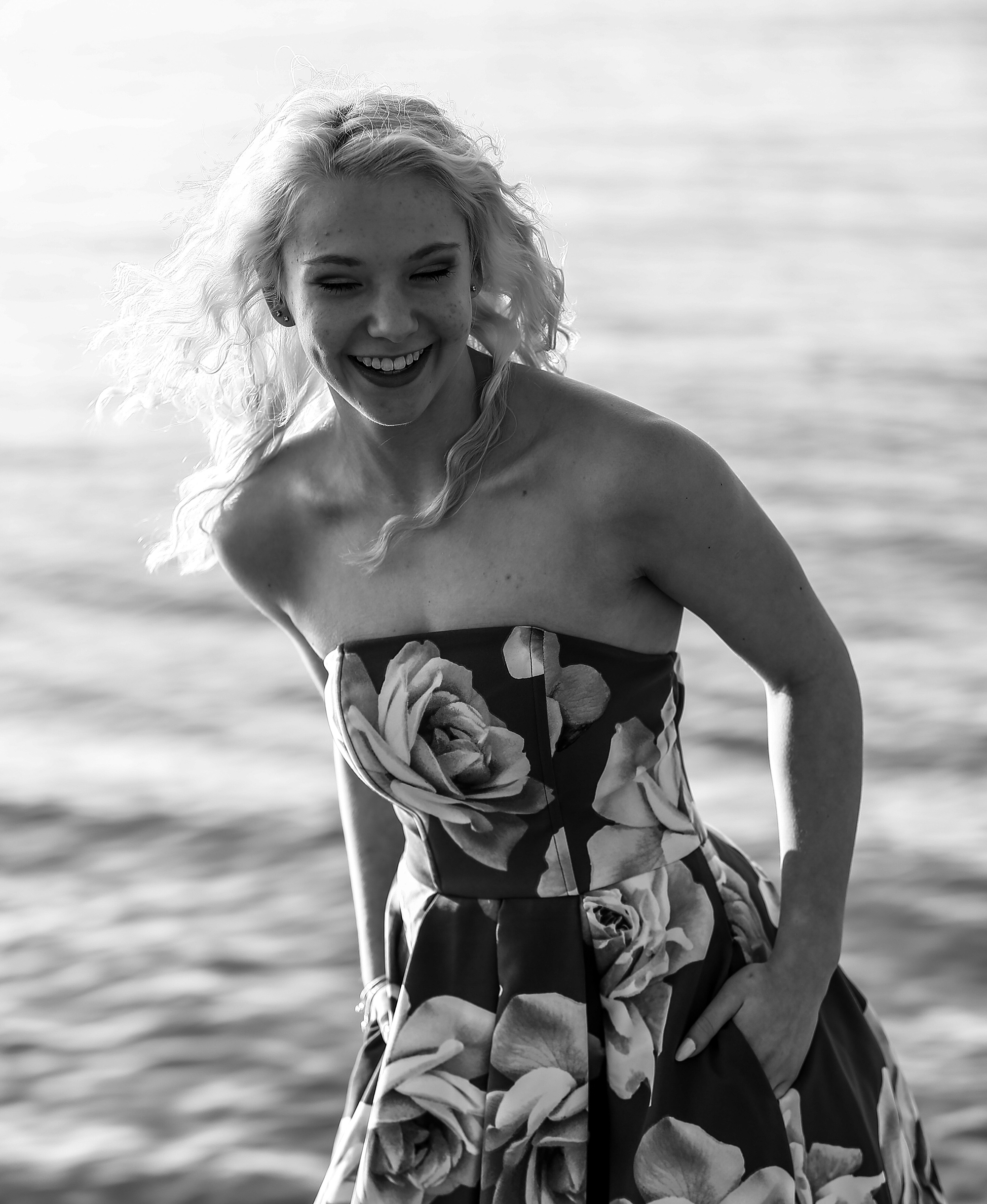 Girl wearing floral print dress laughing for Sweet Sixteen photos at Presque Isle