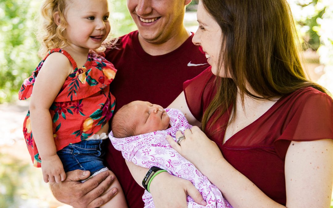 Parents, toddler and newborn baby during summer family photos at Frontier Park