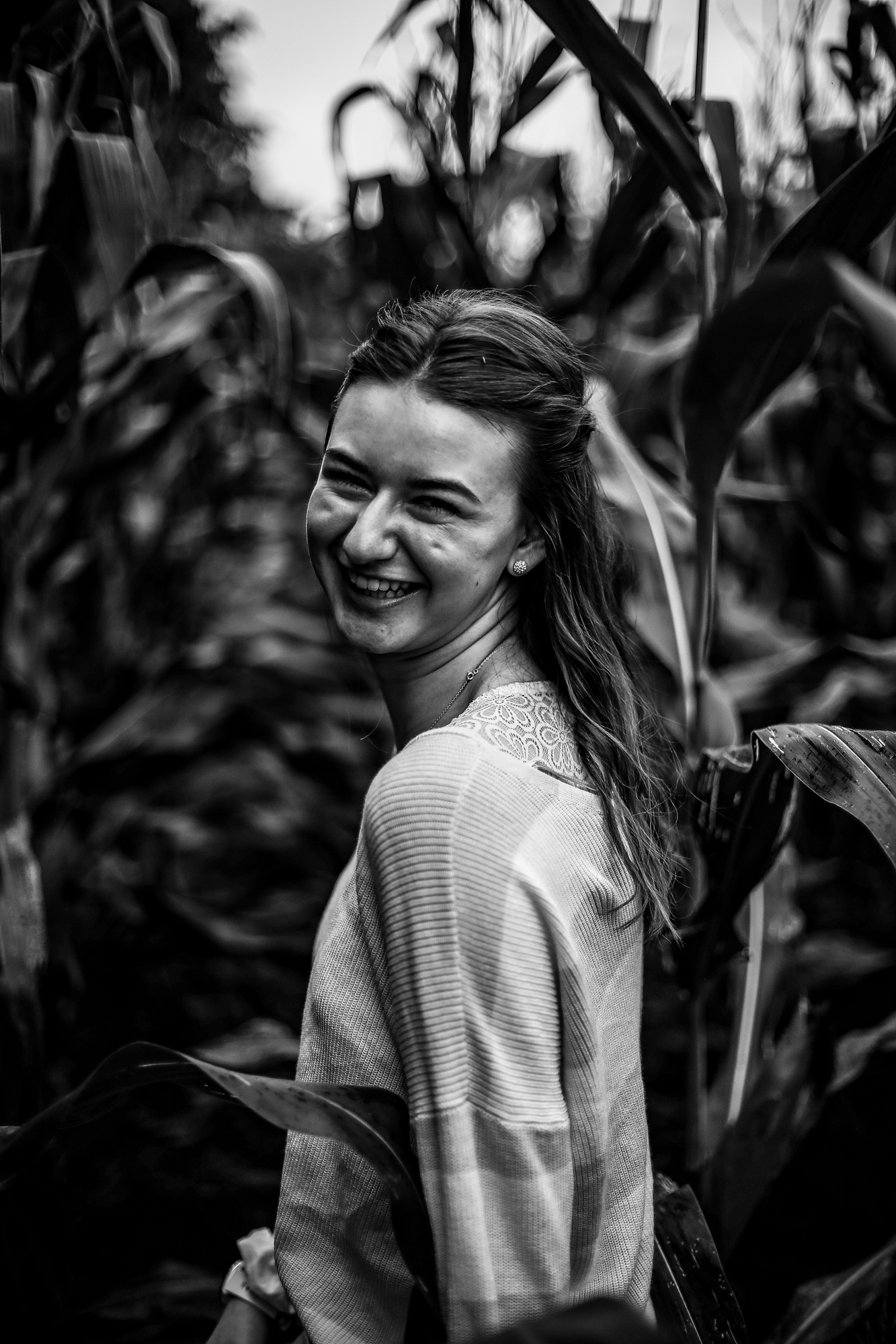 Girl walking through a corn field during rustic senior portraits
