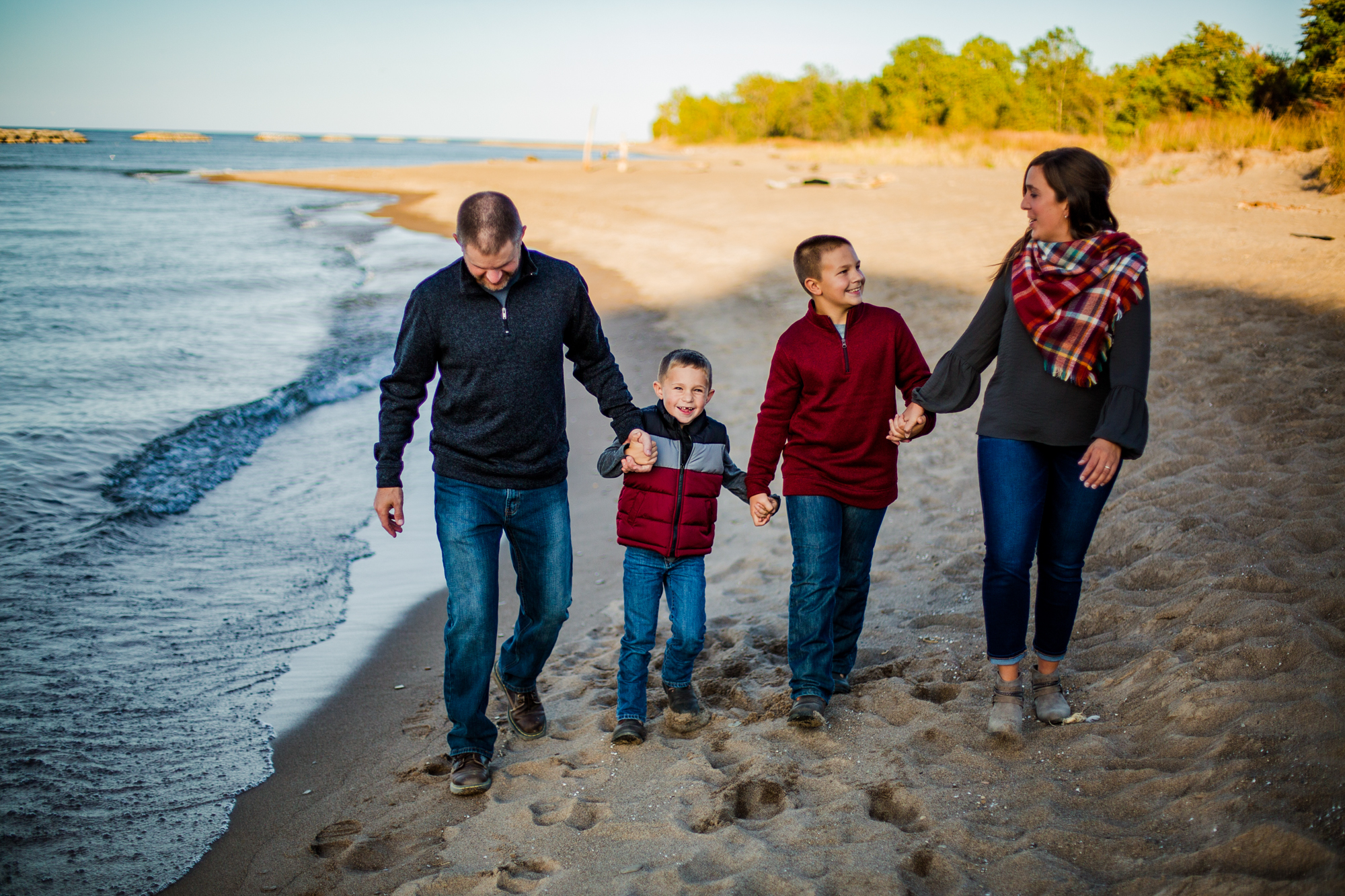 Family walks on the beach at Presque Isle State Park during portrait session