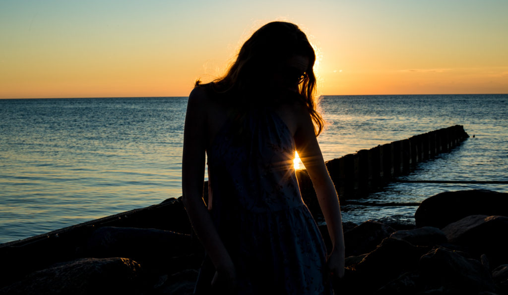 Silhouette of girl at Presque Isle during sunset for summertime senior photos in Erie, PA