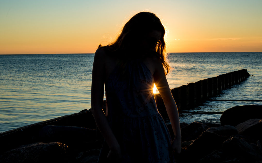 Silhouette of girl at Presque Isle during sunset for summertime senior photos in Erie, PA