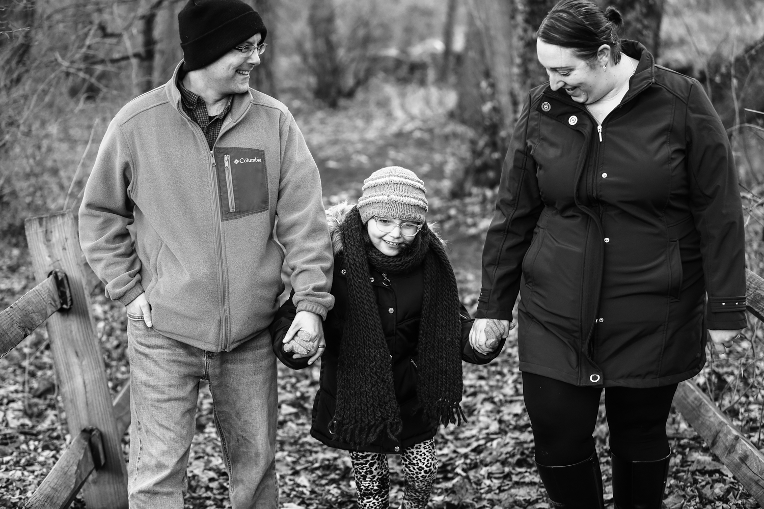 Mother, father, and daughter hold hands during Frontier Park family portraits session