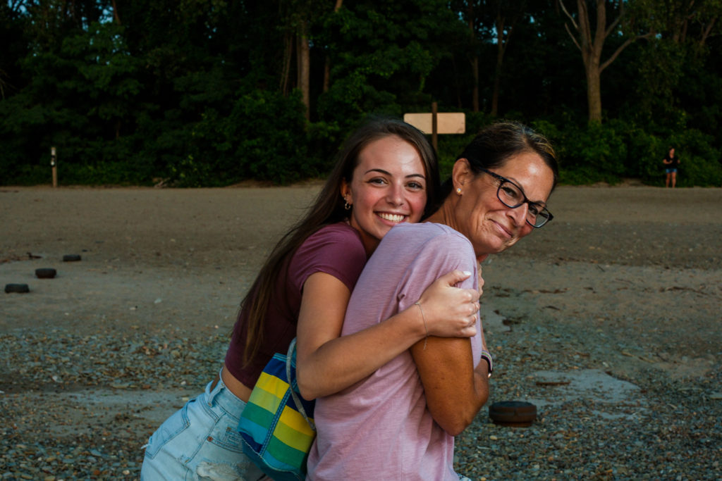 Senior girl hugs her mom during photos on a Presque Isle beach in Erie PA\