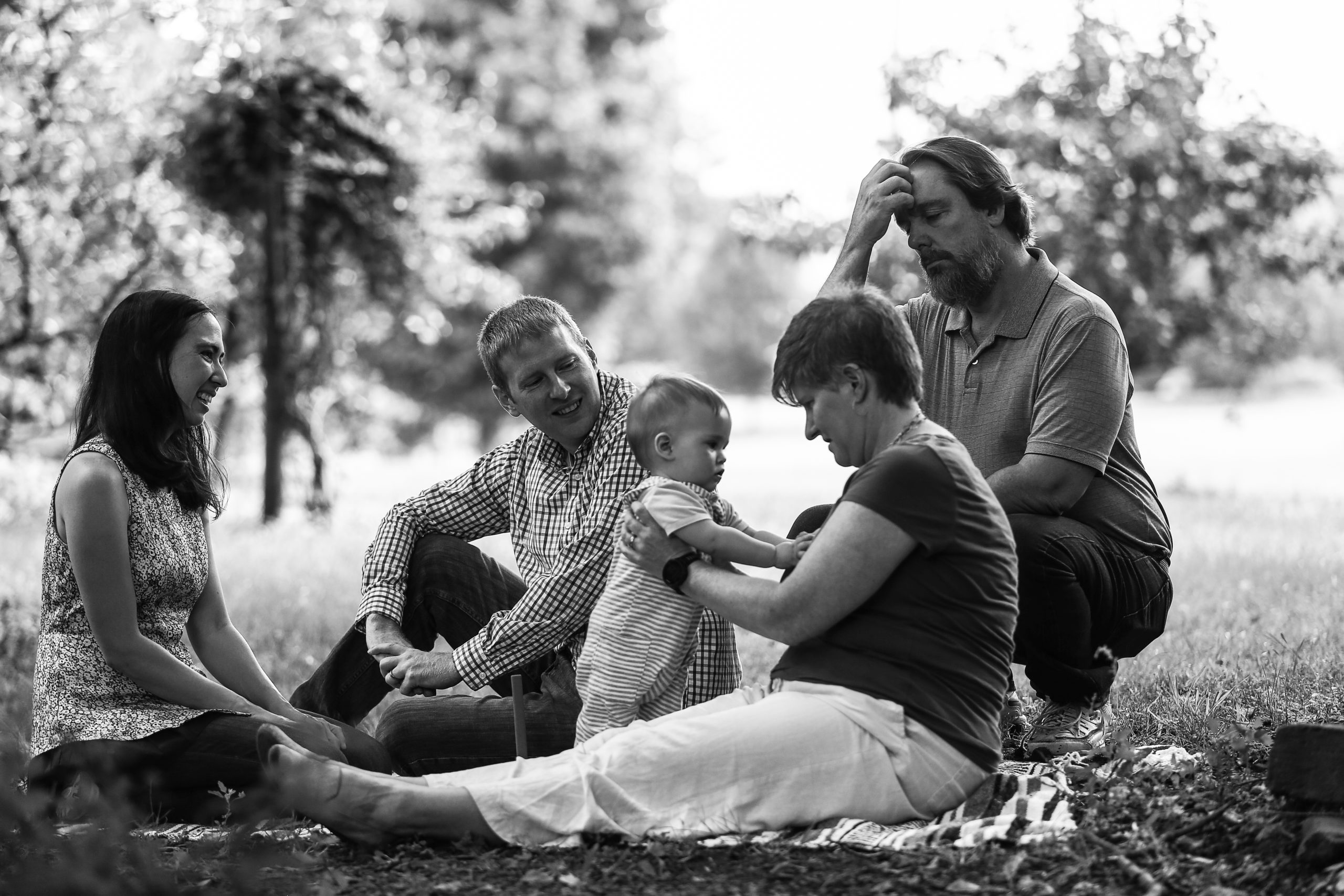 Grandparents, parents, and baby in a park.
